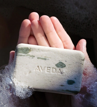 Aveda soap bar product in hands with foam – premium sustainable haircare products featured by Eddine Belaid Switzerland