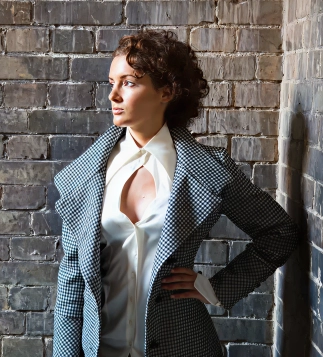 Bold curly hairstyle styled by Eddine Belaid, showcasing modern elegance in a fashion-forward look