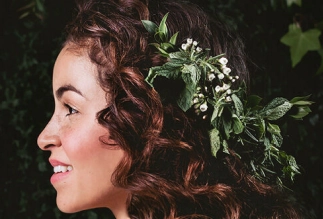 Natural curly hairstyle with green floral accents styled by Eddine Belaid – Celebrating organic beauty and nature-inspired hair design
