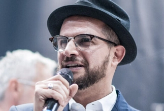 Eddine Belaid speaking on stage – International hairstylist and educator sharing expertise and innovation in beauty and hair design