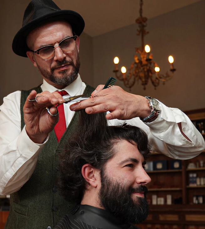 Eddine Belaid hairstylist cutting client’s hair in luxury salon – over 30 years of professional experience with Chanel, Dior, and MCM